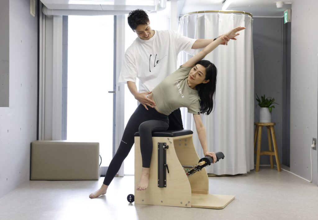 トレーナーと一緒に姿勢を整えている女性